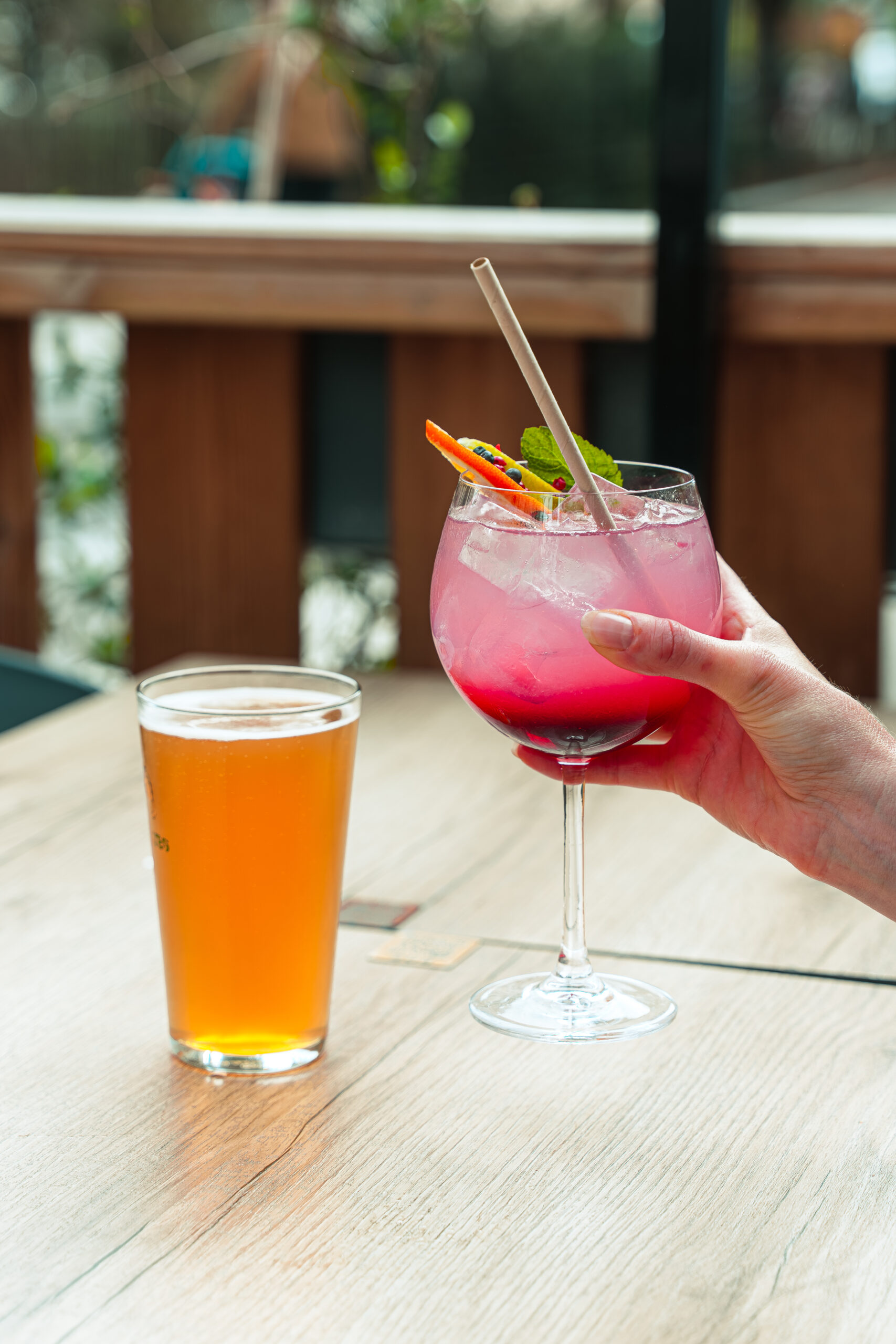 Un verre de bière et un verre de cocktail dans une main